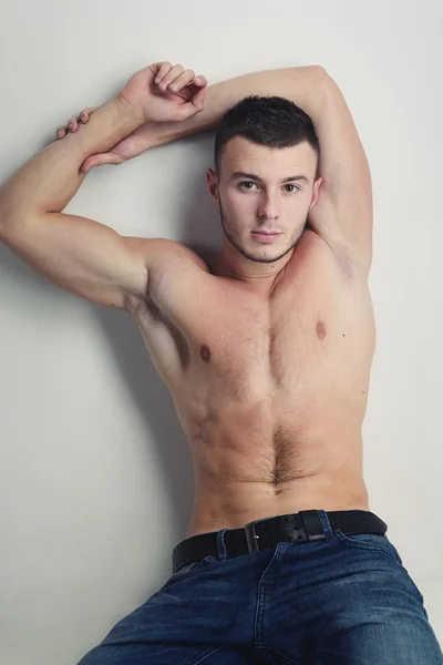 Young handsome guy posing in a studio with a beautiful body