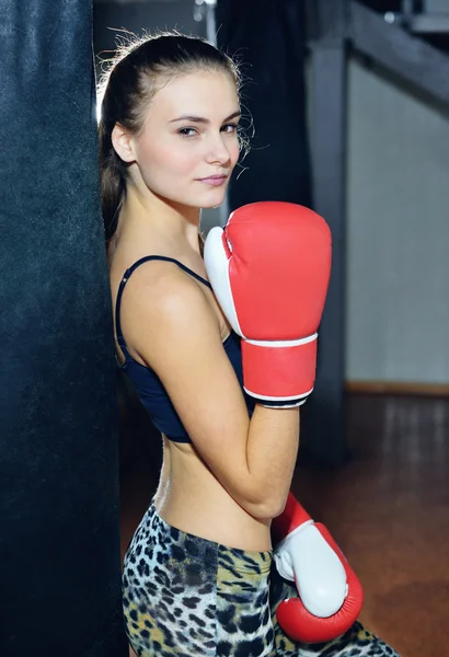 Beautiful girl athlete trains at a boxing gym
