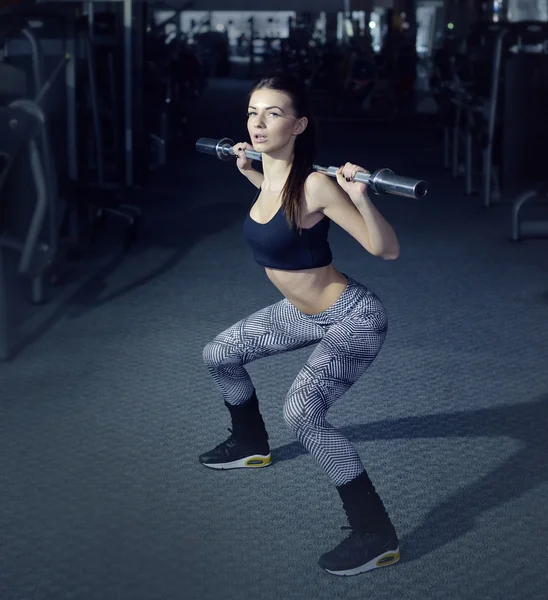 Fitness girl with towel and shaker relaxing in the gym