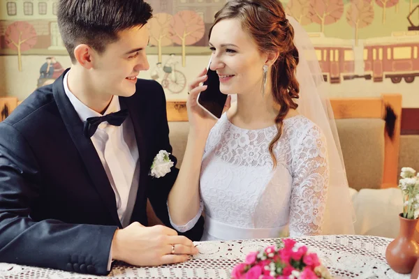 Emotional wedding couple in cafe having fun together.