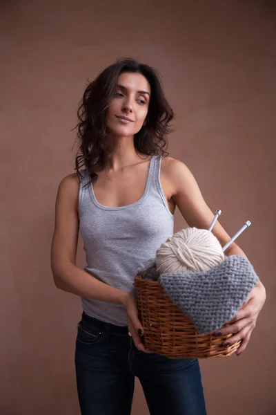 Basket witn yarn ball and knitting needles in woman hands