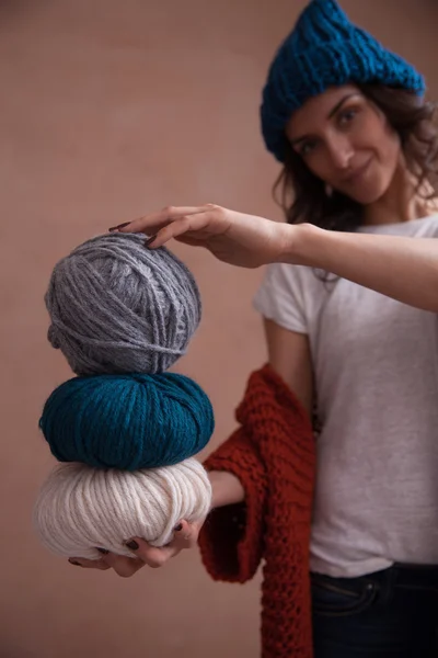 Woman in knit sweater and hat holding the yarn clews