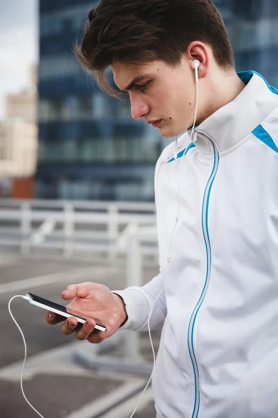 Male athlete with smartphone on downtown