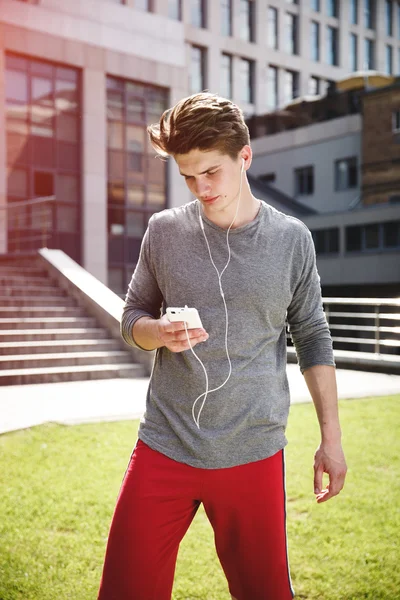 Athlete taking rest with smartphone after urban running