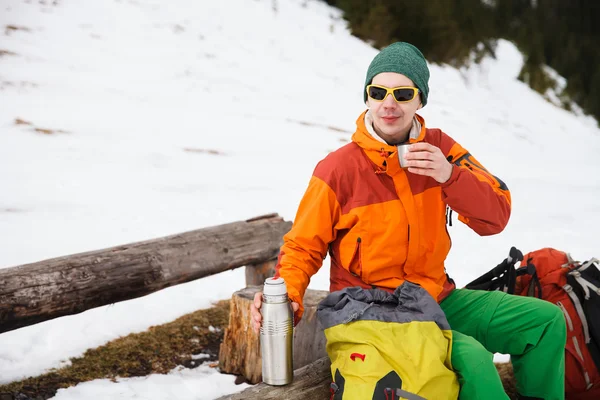 Hiker in winter mountains drink tea