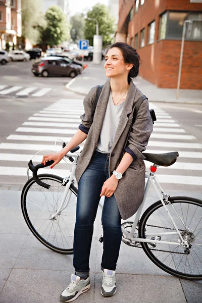 Cheerful middle aged woman riding bike in town