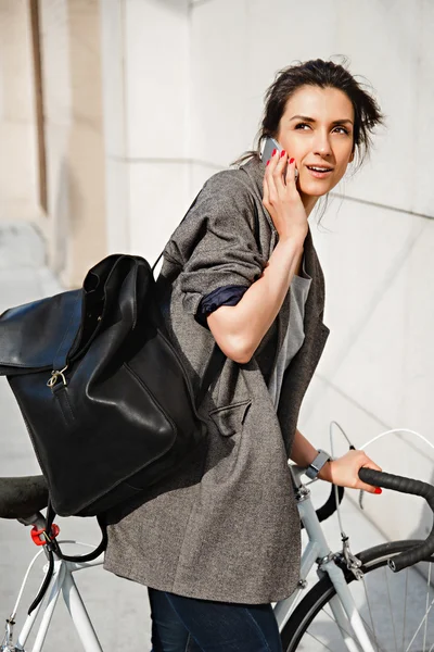 Cheerful middle aged woman riding bike in town