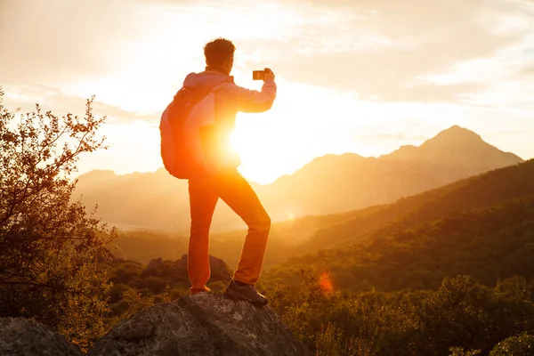 Hiker stands on the cliff over the sunrise