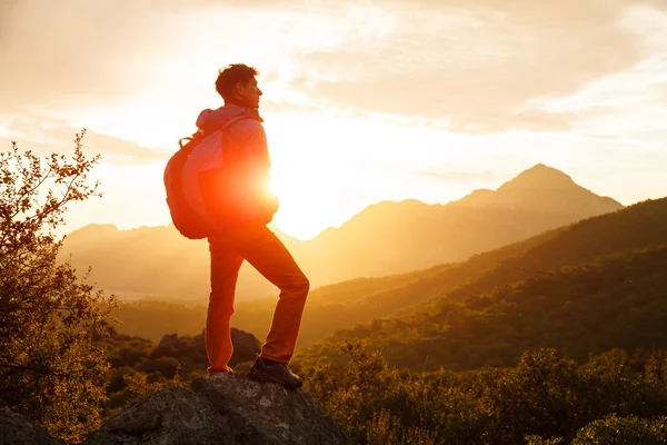 Hiker stands on the cliff over the sunrise