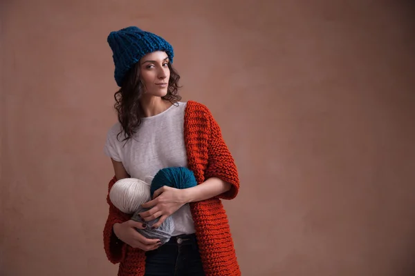 Woman in knit sweater and hat holding the yarn clews