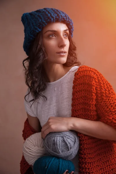 Woman in knit sweater and hat holding the yarn clews