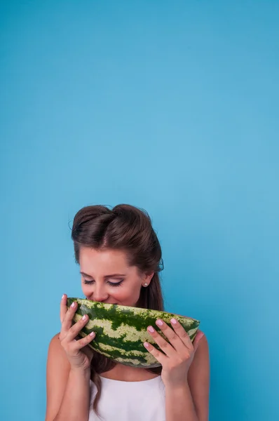 Picture of happy young woman holding a big slice watermelon in the studio