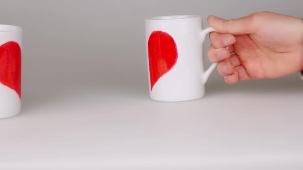 手里捧着两杯咖啡涂上一半红色心形和放近使一