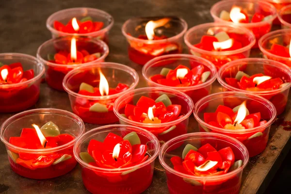 Burning red flower candle at chinese shrine for making merit in