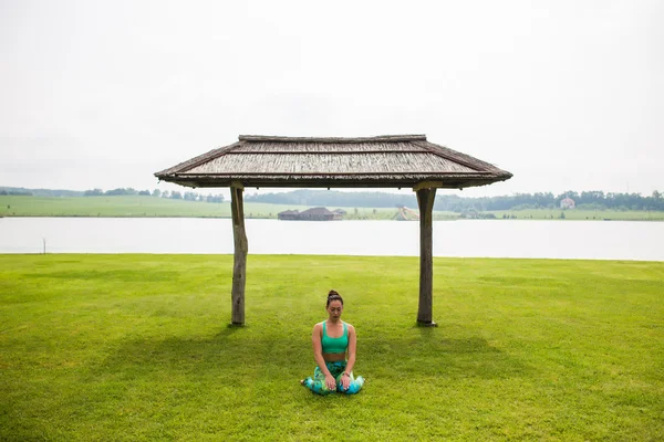 Yoga girl training outdoors on nature background. Yoga concept.