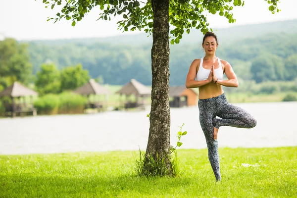 Yoga girl training outdoors on nature background. Yoga concept.