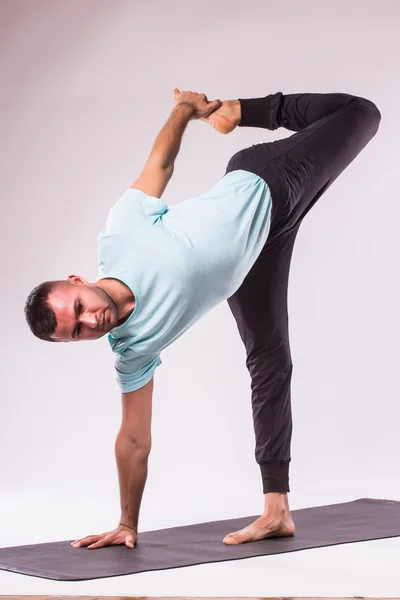 An attractive athletic man doing a yoga pose