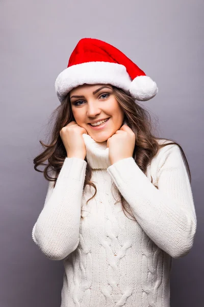 Beautiful happy young Caucasian brunette woman wearing Santa Claus beanie hat .