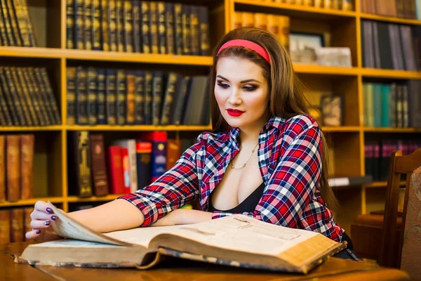Clever female student hair ponytail girl  sitting  in  library with  books. Indoor