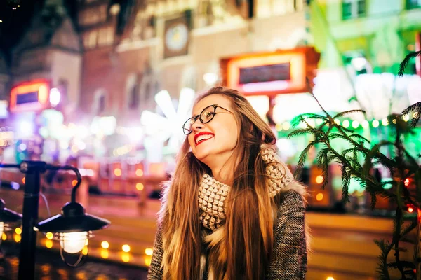 Street portrait of smiling beautiful young woman on the festive Christmas merket.