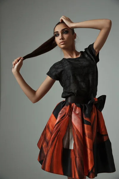 The slim model in exclusive printed skirt is demonstrating the new trendy fashion collection