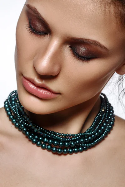Elegant young lady with evening glamorous make up and beautiful necklace jewelry on her neck. Gorgeous woman face.