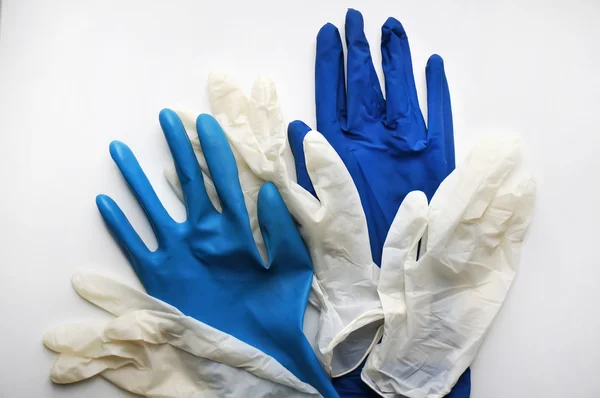 Pairs of rubber gloves on white.