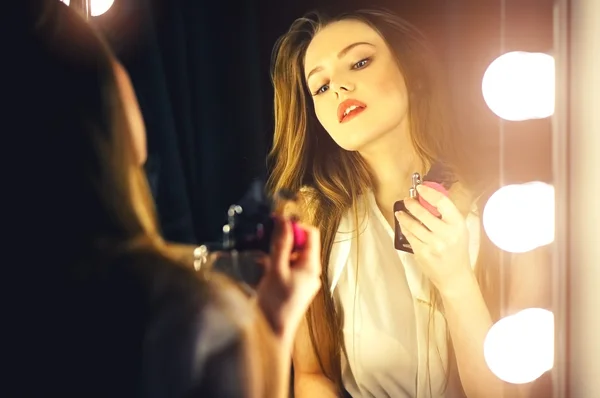 Sexy young woman looking into a mirror at herself