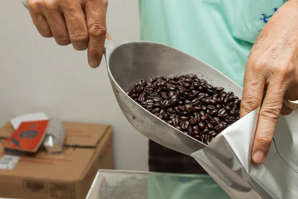 Worker filling coffee bean in package