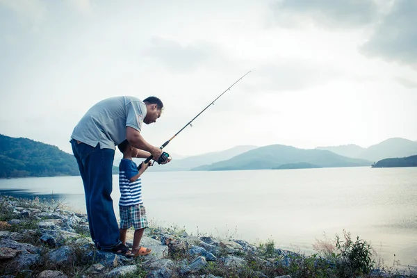 Son and dad fishing at dam,vintage tone