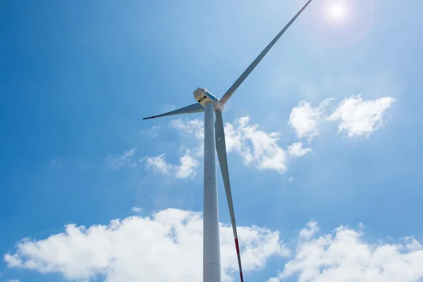 Cloes up wind turbine towers on blue sky background