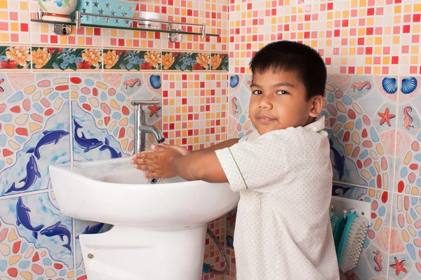 Little boy washing hand in the bathroom