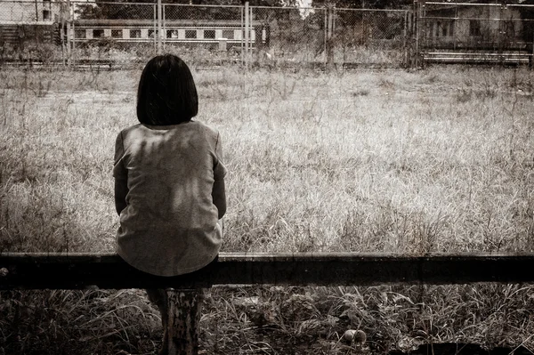 Sad asian girl sitting alone  near railway Stations