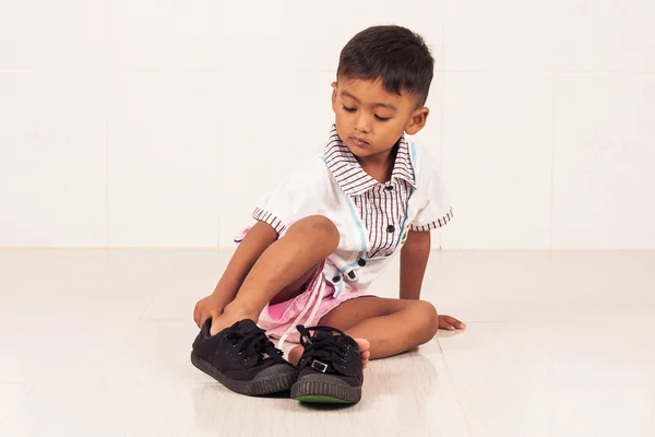 School boy wearing big shoe