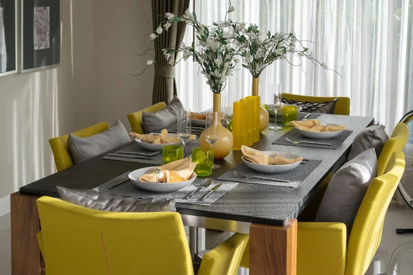 Dining table and comfortable chairs in modern home with elegant table setting