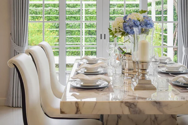 Dining table and comfortable chairs in vintage style with elegant table setting