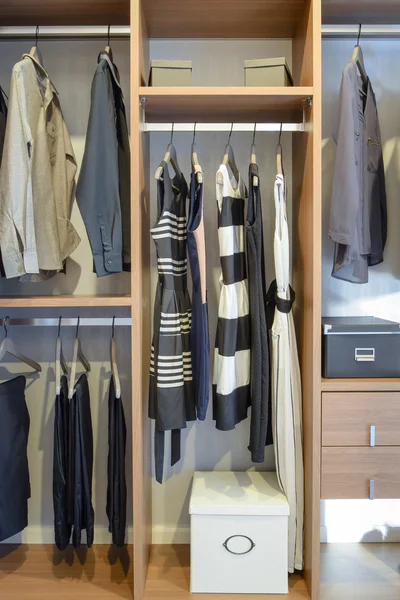 Row of black dress,shirts and pants hang in wardrobe