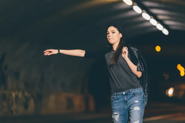 Woman at night road waving for car