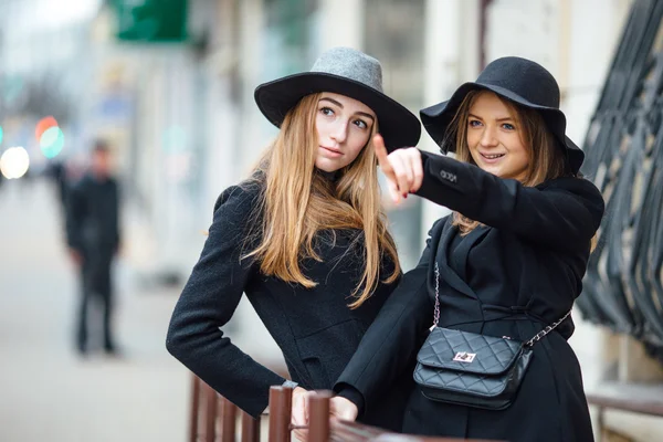 Two young girls walking on the street and posing to camera