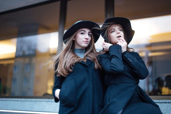 Two young girls walking on the street and posing to camera