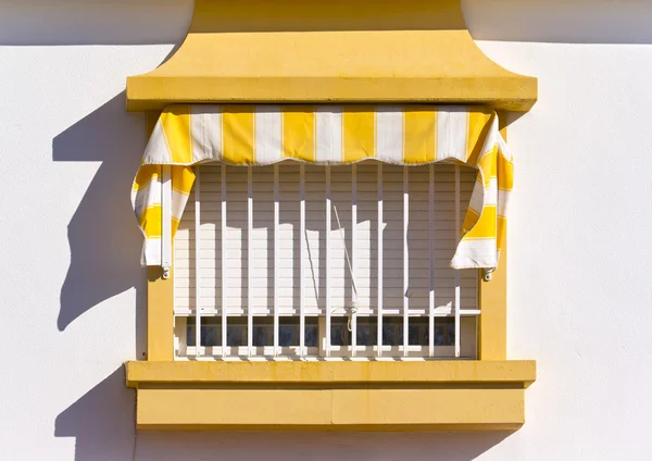 Spanish Window with white and yellow awning