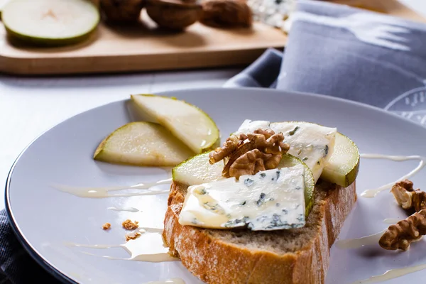 Cheese with slices of pear, nuts and honey