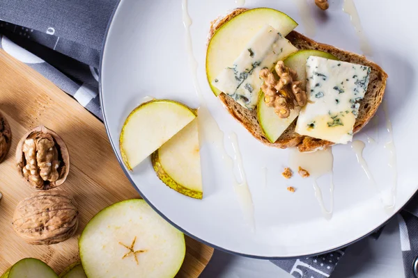 Cheese with slices of pear, nuts and honey