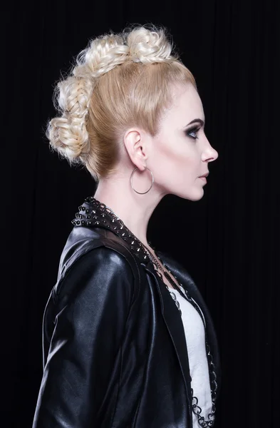 Young attractive blonde in a leather jacket. She is rebellious, she has a creative mohawk and heavy makeup.