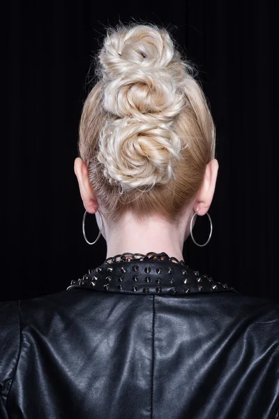 Young attractive blonde woman with creative hairstyle. Back of the head.