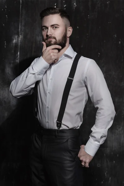 A young handsome bearded man sitting on orange couch in a dark room