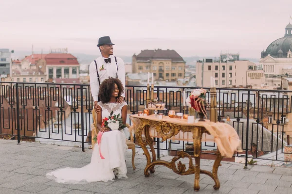 Charming african wedding couple on the terrace with amazing view on Lviv ancient architecture