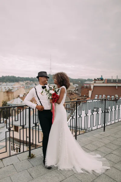 Beautiful african wedding couple lovingly look at each other on the rooftop