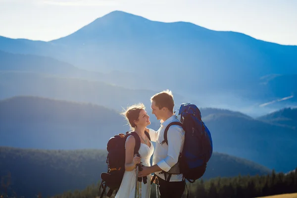 Beautiful tourist wedding couple hugs on the top of mountain. Wonderful landscape  background