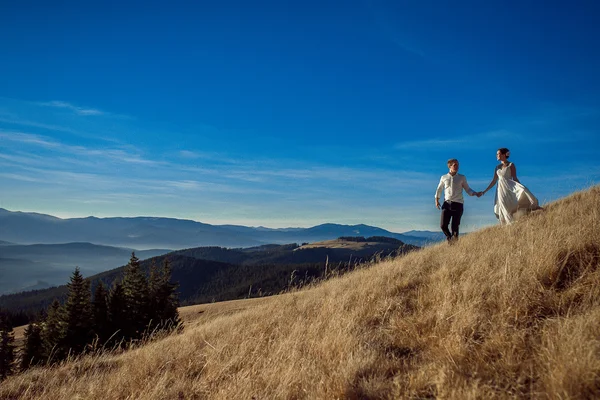 Romantic wedding couple walking in the mountains.